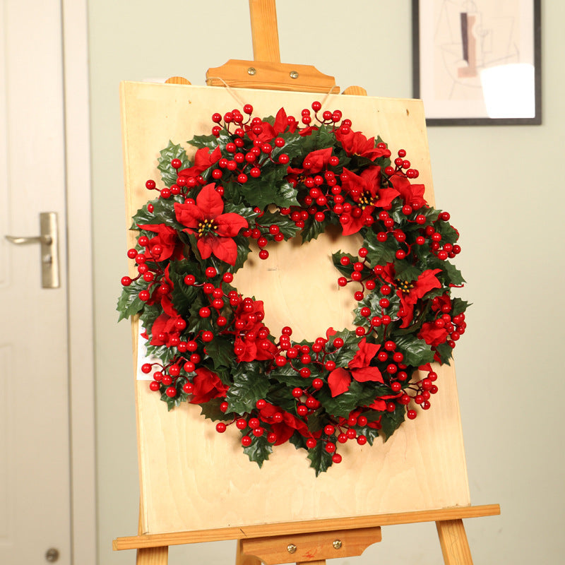 Couronne de Noël rouge avec feuilles de trident vert