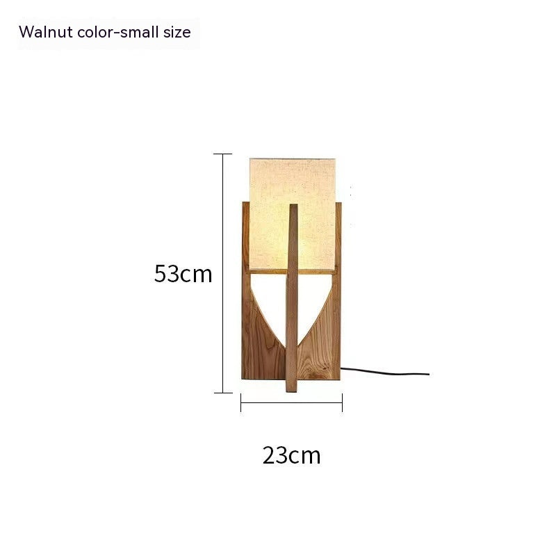 Lámpara de mesa decorativa de madera junto a la cama del dormitorio