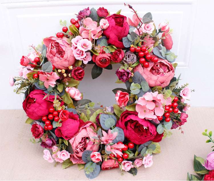 Porte rouge de Noël avec couronne de pivoines d'automne