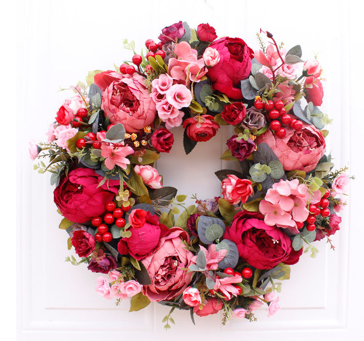 Porte rouge de Noël avec couronne de pivoines d'automne