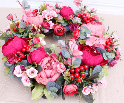 Porte rouge de Noël avec couronne de pivoines d'automne