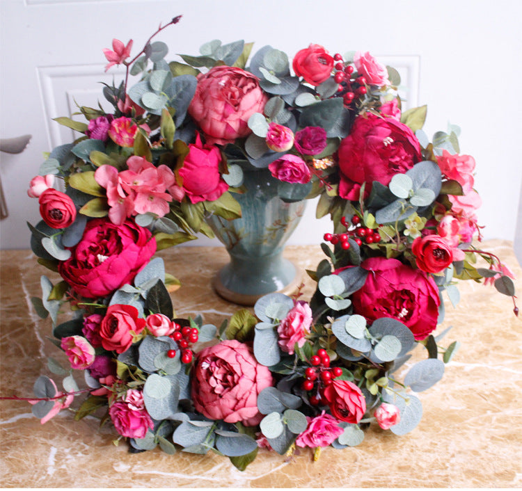 Porte rouge de Noël avec couronne de pivoines d'automne