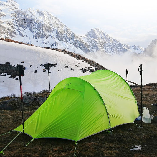 Tente d'alpinisme de camping en plein air entraînée par le vent pour deux personnes