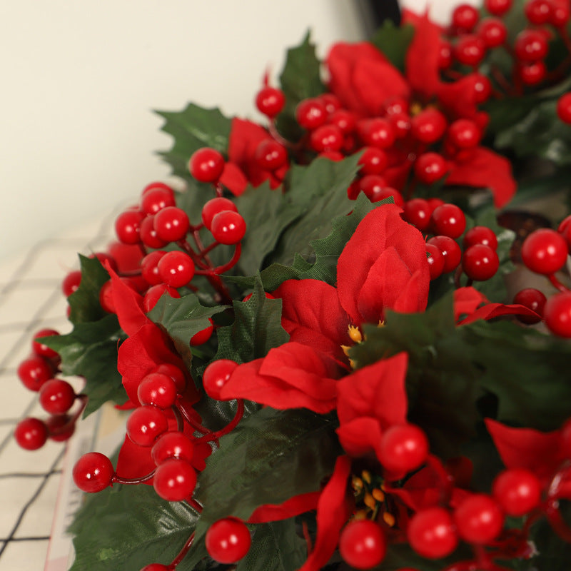 Couronne de Noël rouge avec feuilles de trident vert